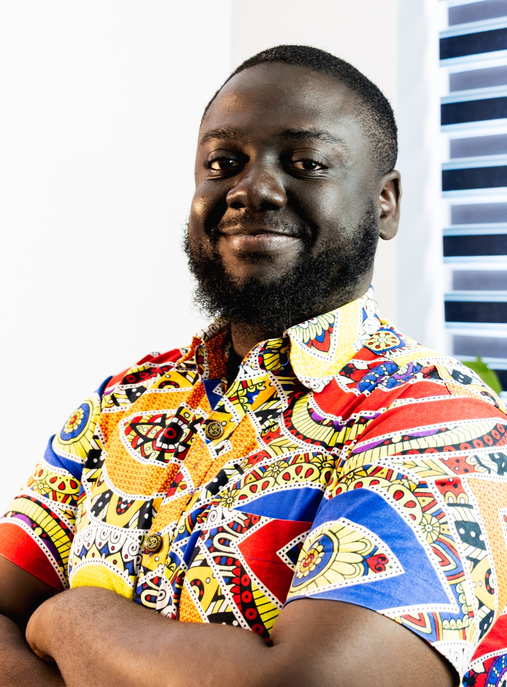 Fiifi Anaman, smiling with his arms folded, wearing a patterned shirt